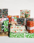 This holiday gift wrap features various kinds of flora printed on a primary green background.