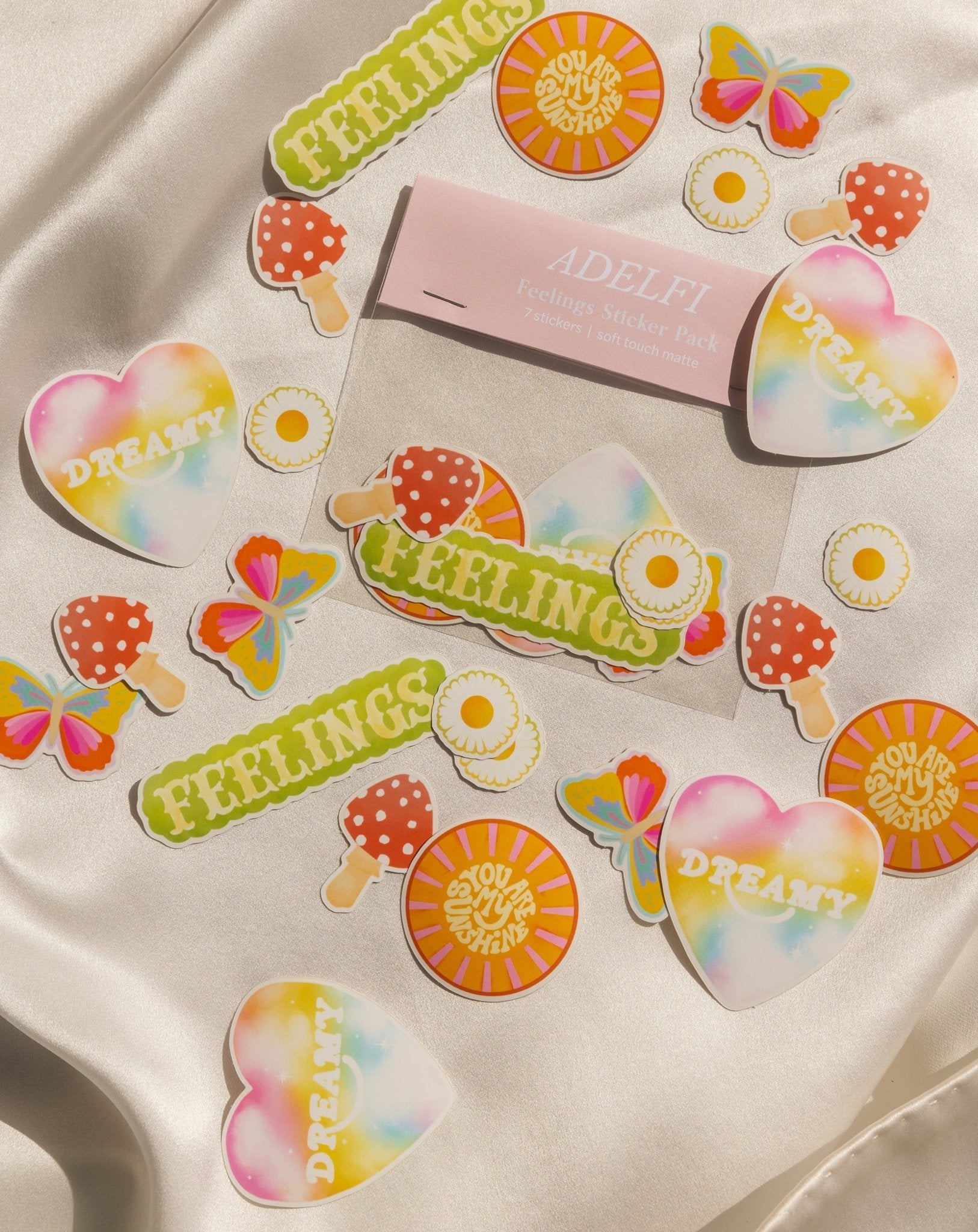 6 new Adelfi stickers: colorful butterfly, the word &#39;Feelings&#39; in all caps, two daisies, the words &#39;you are my sunshine&#39; in a sun, red mushroom, and the word &#39;Dreamy&#39; in a heart.
