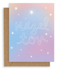 "Mazel Tov" in large, hollow cursive on a gradient blue-lavender background with various kinds of stars printed on cardstock with a kraft envelope.