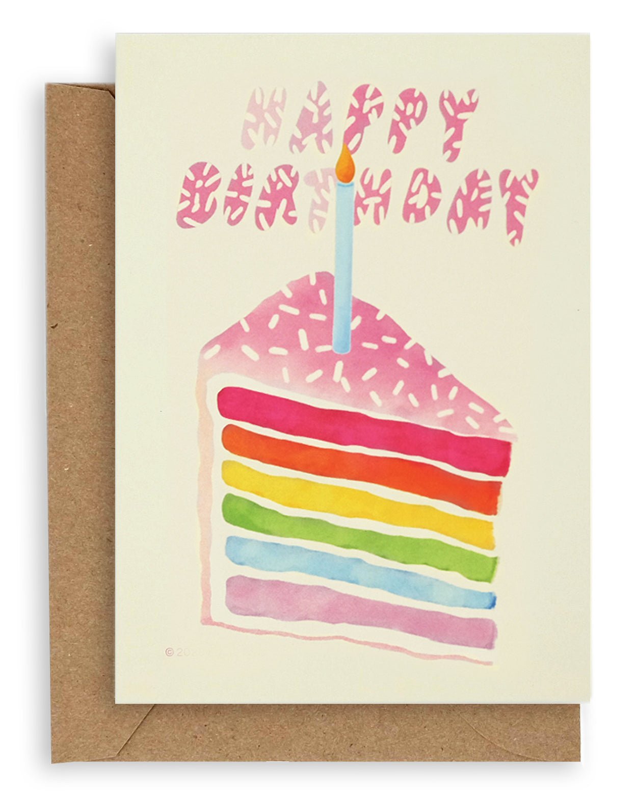 Cream colored card with soft pink text that reads "Happy Birthday" with white sprinkles on it. Below the text is a soft pink cake of the same shade with white sprinkles on top and rainbow colored layers inside of it with a kraft envelope under the card.