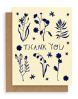 Our forest flowers design, with three stems above and three below vertically  with the words "Thank You" in the middle all in Navy Blue. Printed on a cream colored background. Shown with Kraft envelope. 