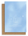 Back of the Adelfi horoscope card, pale blue with white twinkle stars on a kraft envelope.