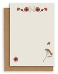 Adelfi monogram "N" notecard with kraft envelopes on a white background.