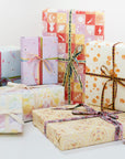 Varying gift wrap designs with varying ribbons.