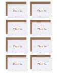 Several rainbow stars thank you cards with rainbow colored letters printed a white cardstock background resting on a kraft envelope.