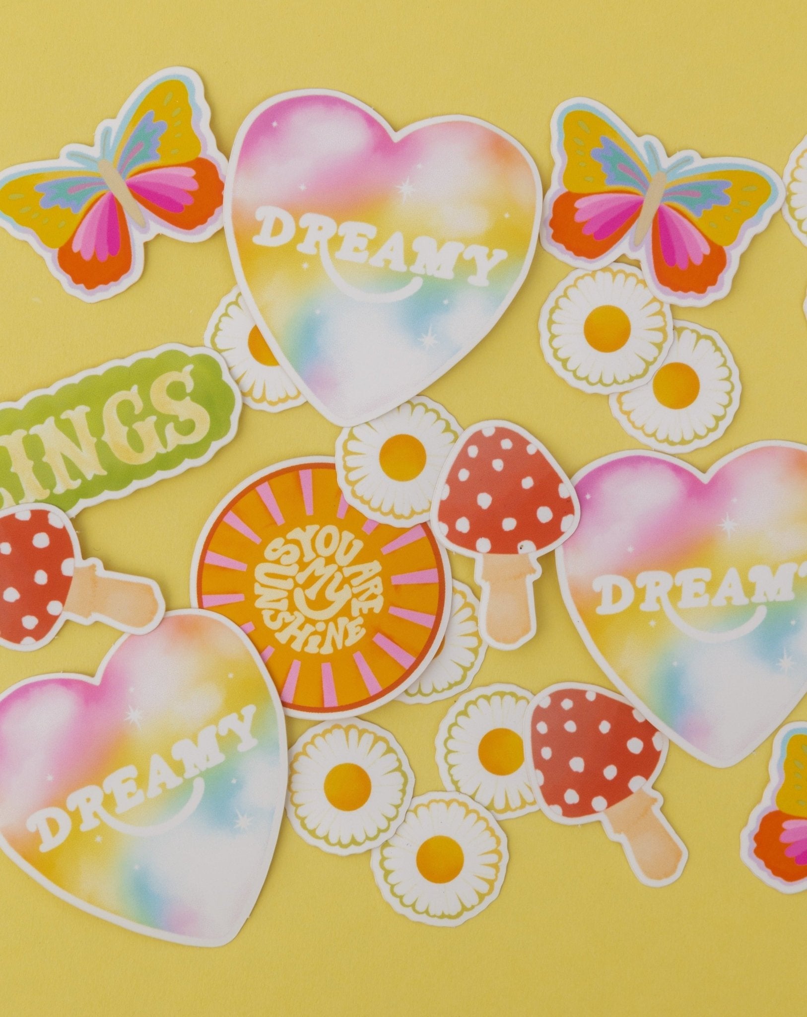 6 new Adelfi stickers: colorful butterfly, the word 'Feelings' in all caps, two daisies, the words 'you are my sunshine' in a sun, red mushroom, and the word 'Dreamy' in a heart.