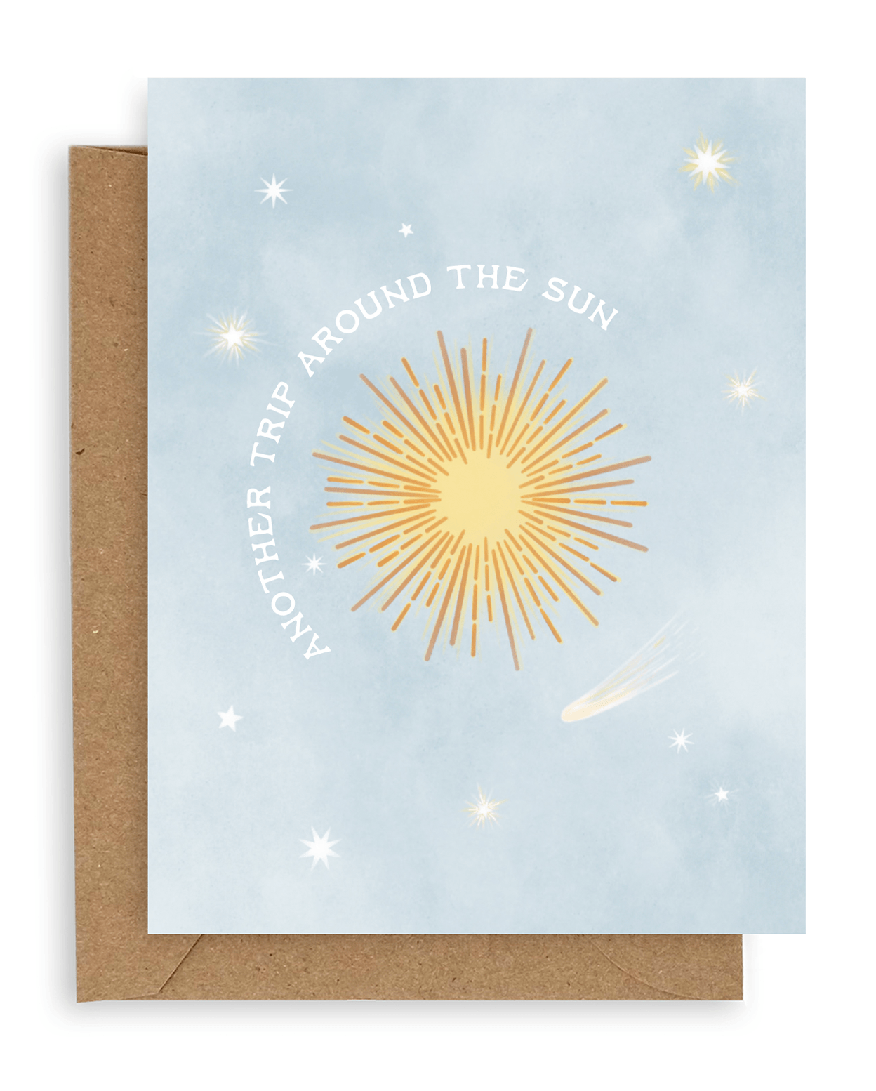Greeting card with a pale blue background and scattered stars, a big yellow sun in the middle is circled by the words &quot;Another Trip Around the Sun.&quot; Shown with kraft envelope.