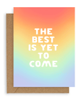 Rainbow gradient background with "The Best Is Yet To Come" in bold, white font printed on cardstock resting on a kraft envelope.