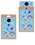 Neon Icons stickers; pink, blue, and orange moths, rainbows, rainbow colored lightning bolts and stars, evil eye, Saturn, Ufo, and a Hamsa hand on a blue sheet against kraft packaging.