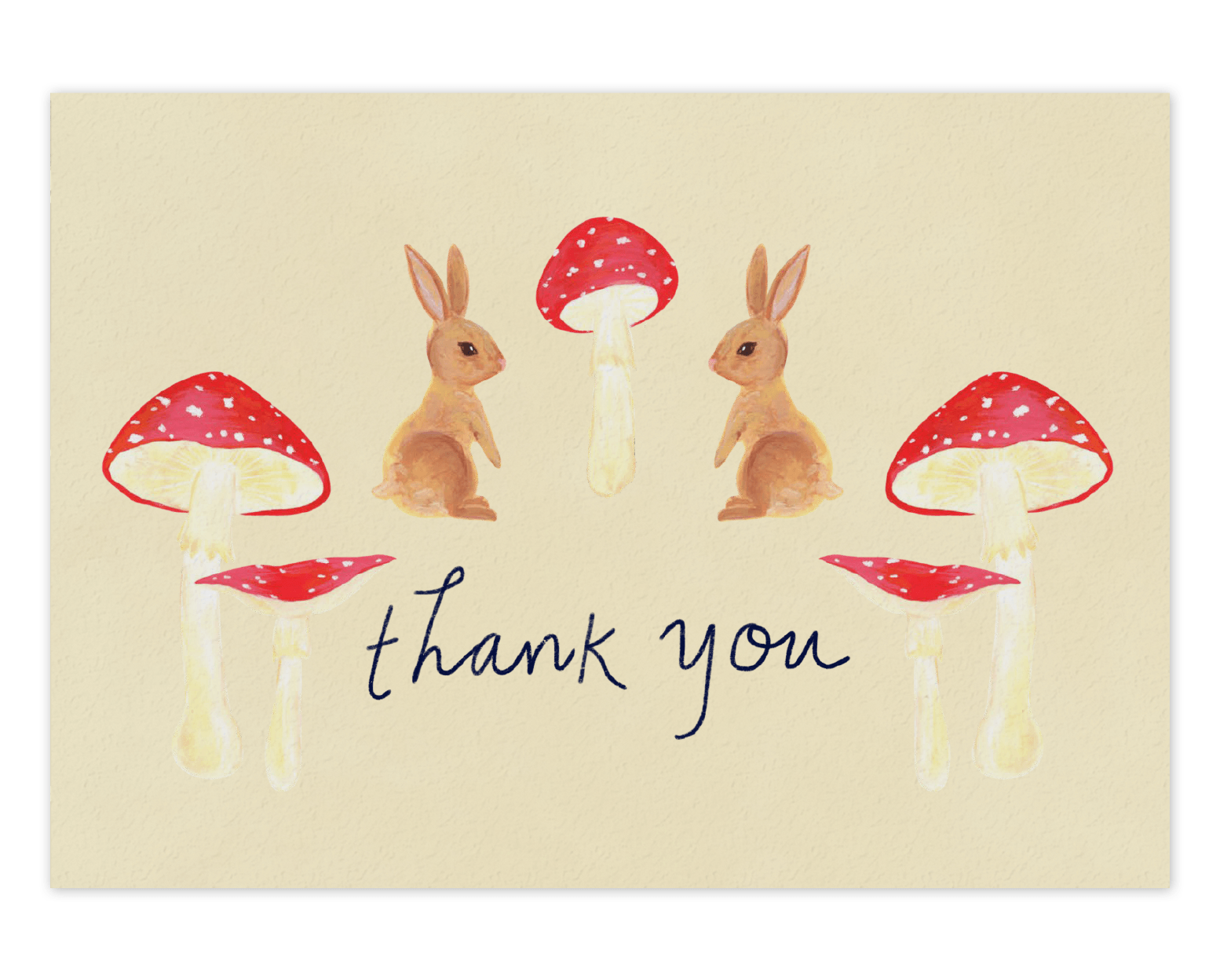 Our new Forest Creatures design! This card features two light brown/dirty blonde rabbits facing each other with a red magic mushroom between them and two red mushrooms on either side of the words &quot;Thank You&quot; printed in black ink on a cream background. 