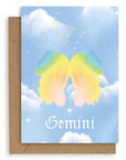 Gemini  Horoscope card with a kraft envelope. The horoscope symbol is painted in rainbow pastel on a blue background with white clouds. 