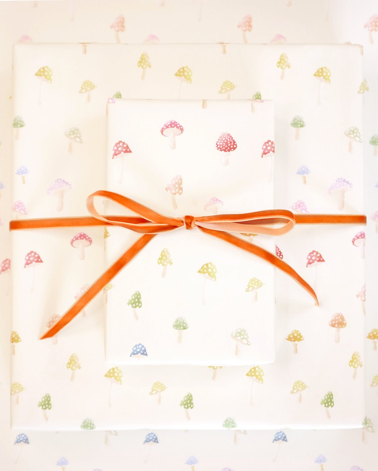 Magic mushrooms gift wrap with orange velvet ribbon.