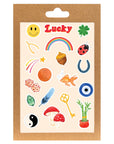 Lucky Charms sticker sheet with varying lucky items on a cream colored sheet: a copper penny, goldfish, four leaf clover, dice, the number seven, bamboo plant, yin and yang, rainbow, horseshoe, shooting star, and smiley face. Shown in kraft packaging. 