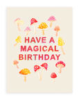 Cream colored card with pink, orange and red mushrooms and red printed text with the words "Have A Magical Birthday" in the middle. Shown on white background.