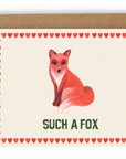 A red fox positioned above the words "such a fox" in green font. Red hearts line the sides of the card. Printed on a cream background. Shown with kraft envelope.