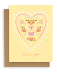 A heart filled with doves, flowers, and hearts with eyes printed on a custard colored background. Shown with kraft envelope.