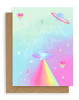Neon icons such as stars, saturn, a ufo, and hearts surround the words "thank you" in hollowed out white font printed on a gradient pink and blue background. Shown with kraft envelope.