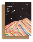 A black sky background with various styles of stars above a rainbow mountain with "Thinking of You" in bold white text aligned at the upper left hand corner of the card printed on cardstock with a kraft envelope.