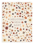"Welcome New Baby" pointillism font design with tightly spaced pressed flowers on a cream colored background printed on cardstock against a white background.