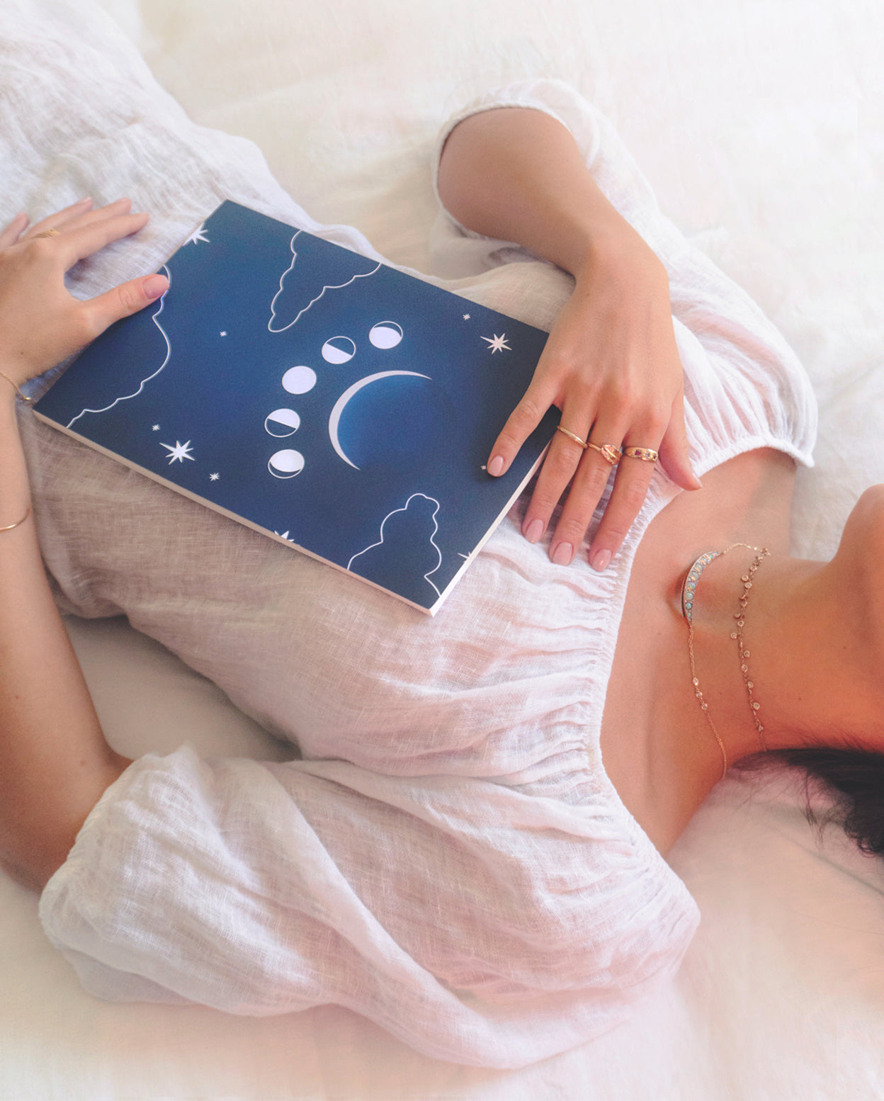 Journal with clouds and moon phases on a dark blue background modeled in use.