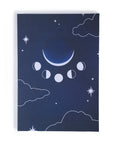 An Adelfi original journal design set in a dark blue night sky with cloud outlines, stars, and moon phases. Behind the journal is a white background.