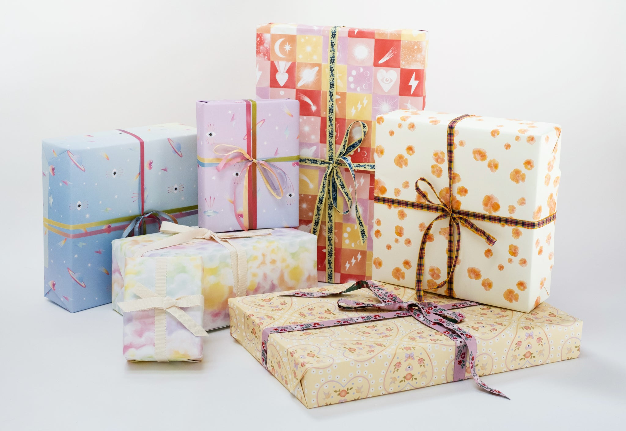 Varying gift wrap designs with varying ribbons.